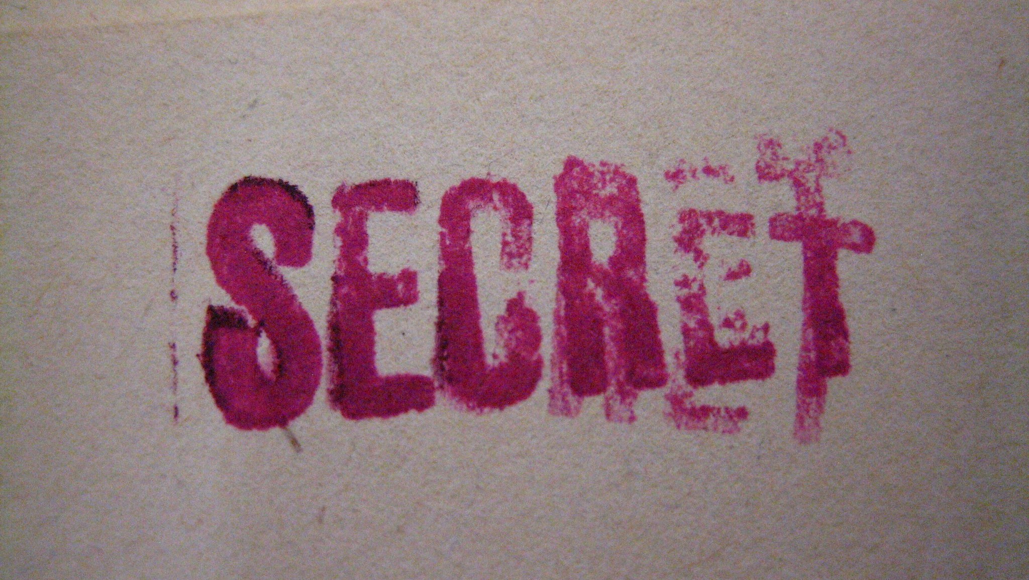 Blurred purple stamp on document, reading "secret"