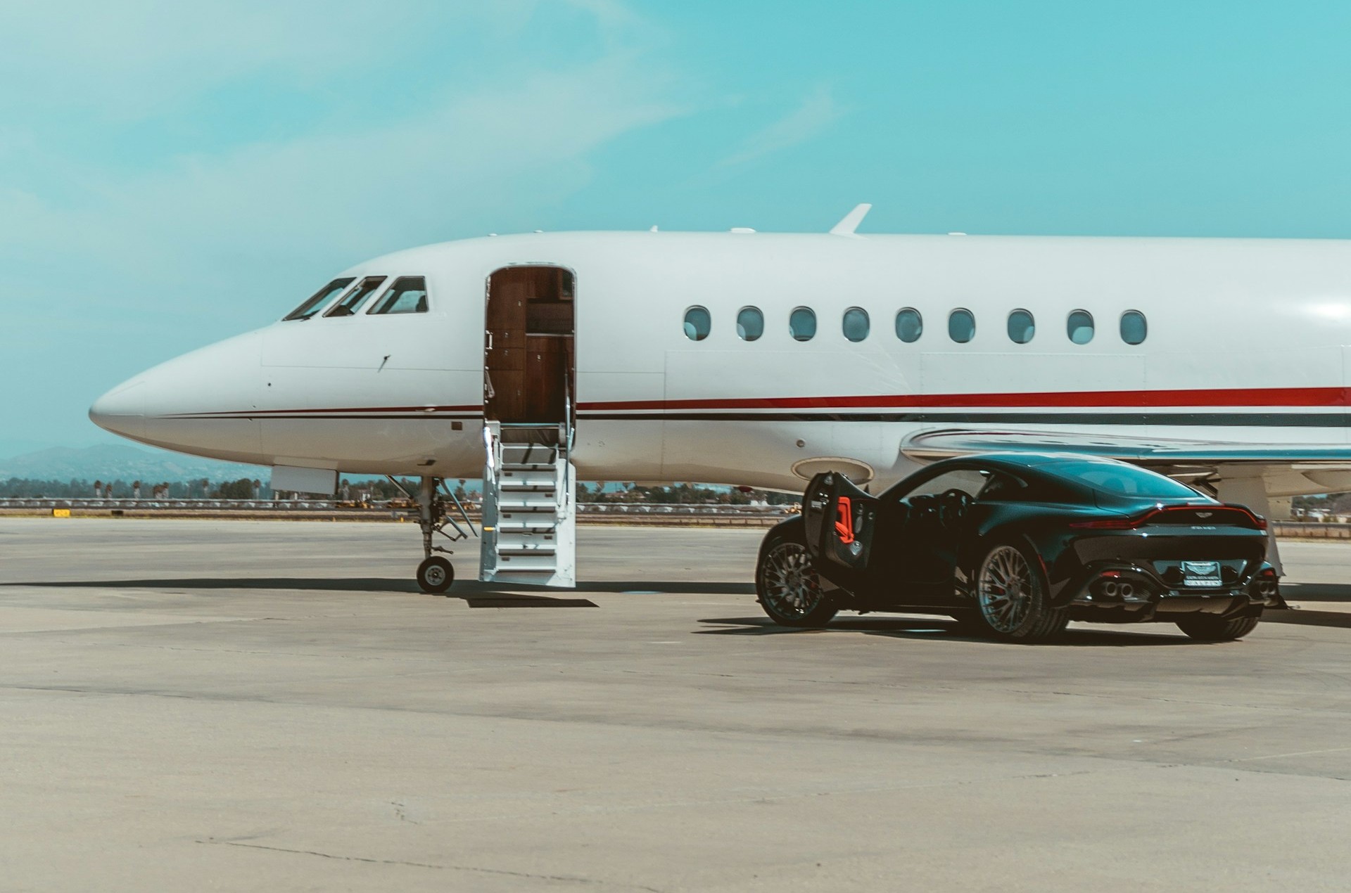 alen-kajtezovic-EgIaYjcI3DQ-unsplash A private jet with a fancy car parked next to it.